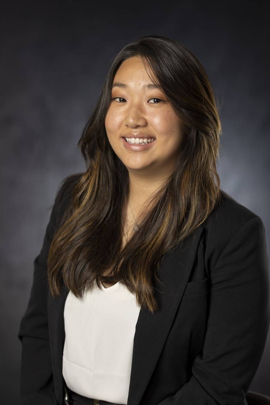 Business headshot of a woman in a black blazer and white blouse